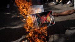 インド在住のミャンマー市民が国軍司令官の写真を燃やす＝３日、ニューデリー