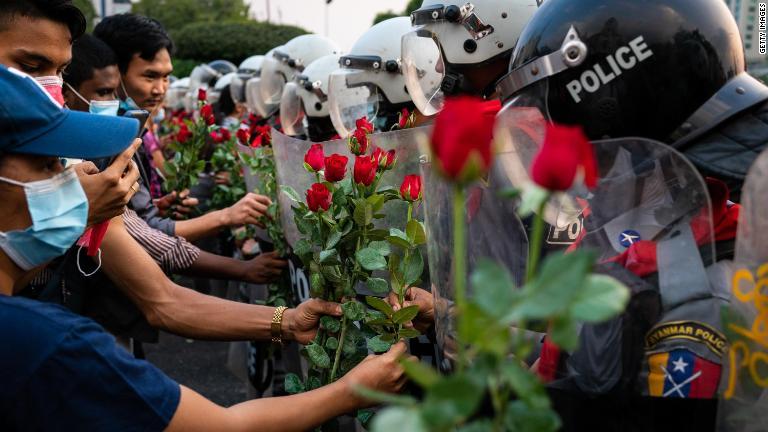 抗議デモ隊が警官隊にバラを渡す＝２月６日、ヤンゴン/Getty Images