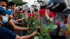 抗議デモ隊が警官隊にバラを渡す＝２月６日、ヤンゴン