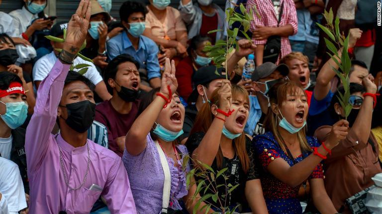 デモ参加者がスローガンを叫ぶ＝２月２５日、ヤンゴン/Stringer/AP