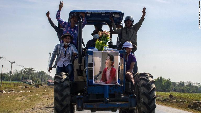 農民がスーチー氏のポスターを掲げてトラクターを走らせる＝１２日、トングワ/Stringer/AFP/Getty Images