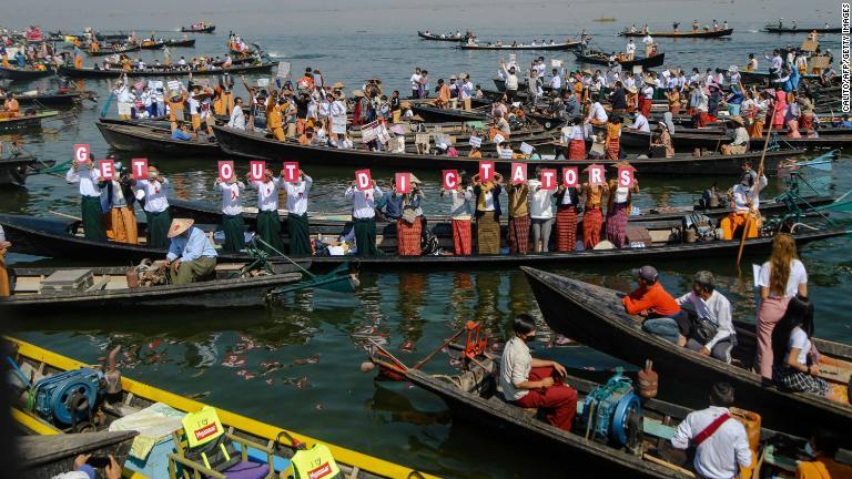 「独裁者は出ていけ」との文字を掲げる人々＝２月１１日、インレー湖/Calito/AFP/Getty Images