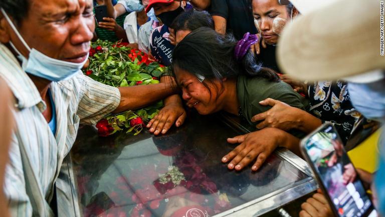 死亡したデモ参加者の妻が夫のひつぎの上で泣き崩れる＝５日、ヤンゴン/Stringer/AFP/Getty Images