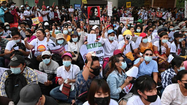 工場労働者がプラカードを掲げ、スローガンを叫びながら抗議デモに参加＝２月２５日、ヤンゴン/Stringer/Reuters