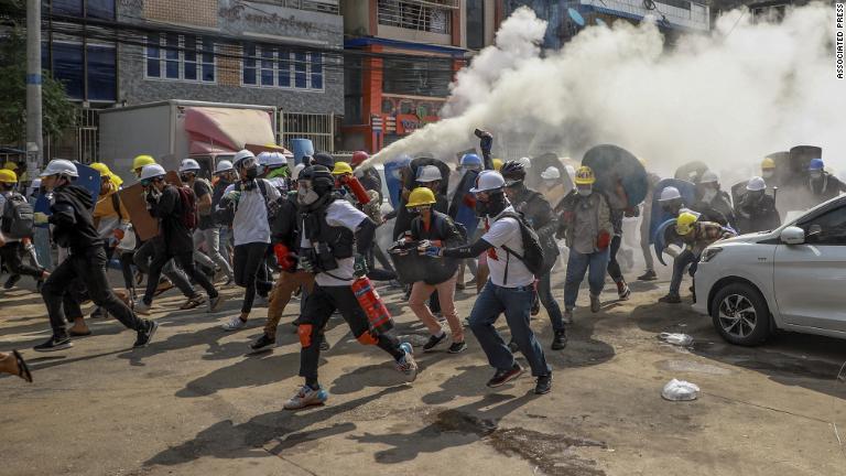 催涙ガスに対抗し消火器を噴射するデモ参加者＝３日、ヤンゴン/Associated Press