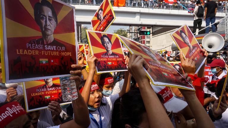 民主化リーダーのアウンサンスーチー氏の写真を掲げる抗議デモ参加者＝２月２２日、ヤンゴン/Sai Aung Main/AFP/Getty Images