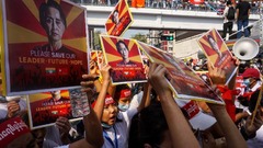 民主化リーダーのアウンサンスーチー氏の写真を掲げる抗議デモ参加者＝２月２２日、ヤンゴン