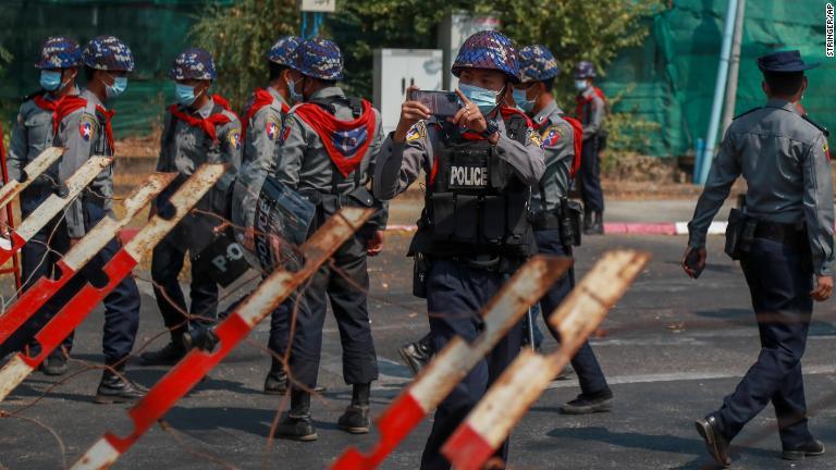警察官がインドネシア大使館付近の抗議デモ参加者を撮影＝２月２４日、ヤンゴン/Stringer/AP