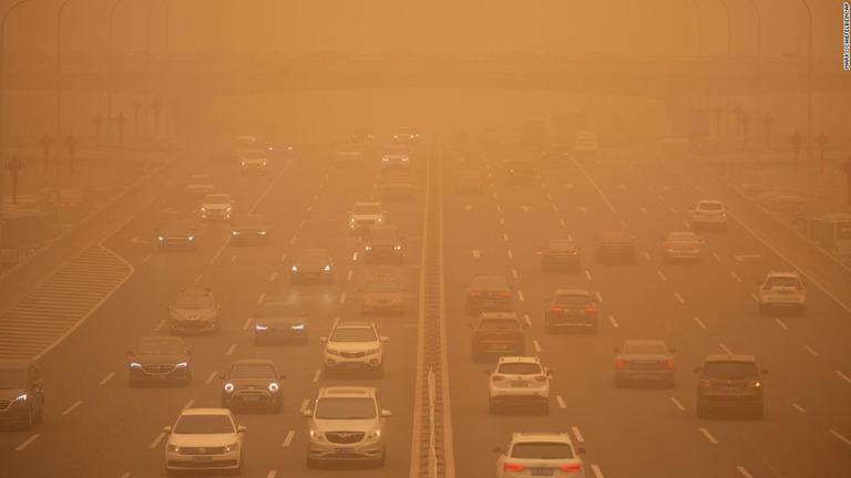 黄砂の中、朝のラッシュ時に高速道路を走る車＝１５日/Mark Schiefelbein/AP