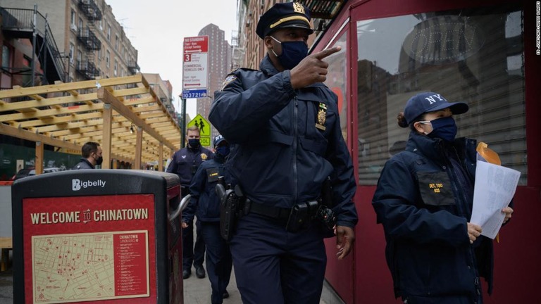 ヘイトクライム（憎悪犯罪）の通報に関するリーフレットを配る警察官＝３月１７日、ニューヨーク市/Ed Jones/AFP/Getty Images