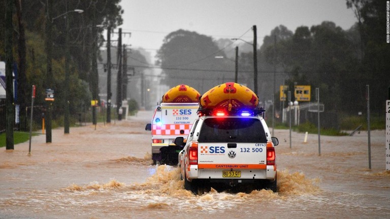 冠水した道路を移動する救急車両＝２０日、オーストラリア・シドニー西部/Saeed Khan/AFP/Getty Images