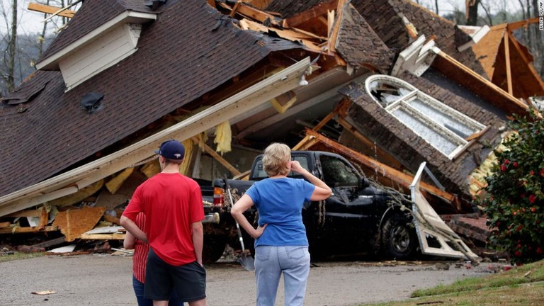 倒壊した家屋を見る住民ら＝２５日、米アラバマ州バーミンガム/Butch Dill/AP