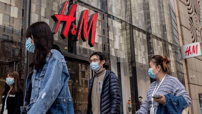 Ｈ＆Ｍの店舗前を歩く人々＝２５日、中国・北京/NICOLAS ASFOURI/AFP/Getty Images