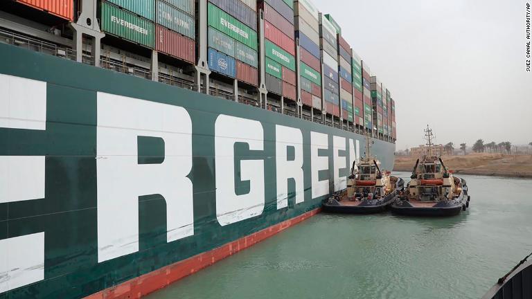 エバーグリーンの船体に横付けするタグボート＝２５日/Suez Canal Authority/AP
