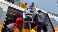 救助隊員の助けを借りて列車から脱出する人