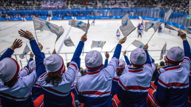 統一旗を掲げて女子アイスホッケーの試合で応援する北朝鮮のチアリーダー＝２０１８年/Carl Court/Getty Images