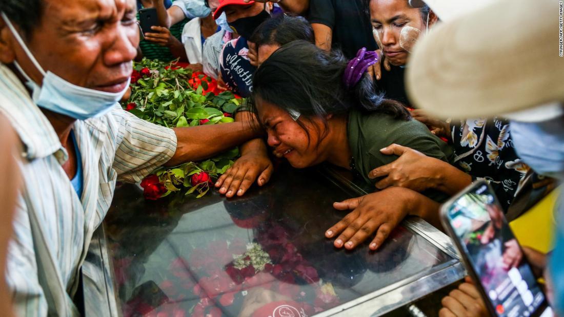 抗議デモに参加していた夫が死亡し、その棺の上で泣き崩れる女性＝３月５日、ヤンゴン/Stringer/AFP/Getty Images