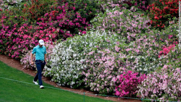 優勝経験者のジョーダン・スピースがツツジの花の前を歩く=9日/Curtis Compton/Atlanta Journal-Constitution/AP