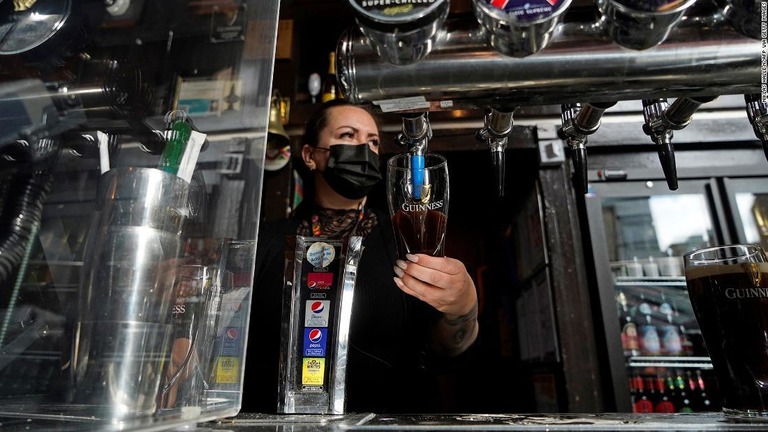 イーストロンドンのパブで黒ビール「ギネス」をグラスに注ぐ従業員/Niklas Halle'n/AFP/Getty Images