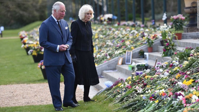 チャールズ皇太子とカミラ夫人がバッキンガム宮殿前に残された花束やメッセージを見る様子/JEREMY SELWYN/POOL/AFP/Getty Images