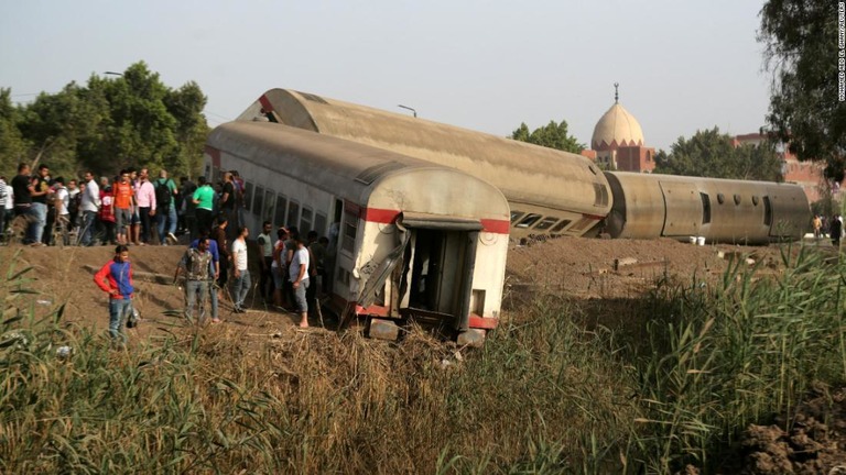 カイロ北郊で脱線した車両の周囲に集まる人々/Mohamed Abd El Ghany/Reuters