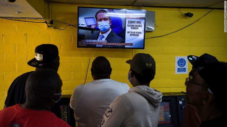 テキサス州ヒューストンでショービン被告の評決を伝えるテレビ画面に見入る人々/Callaghan O'Hare/Reuters