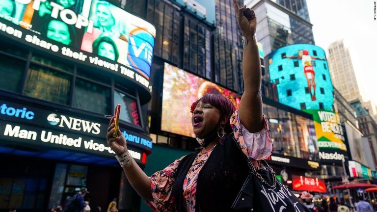 タイムズスクエアを歩きながら、元警官の有罪評決のニュースに反応する黒人女性/Seth Wenig/AP