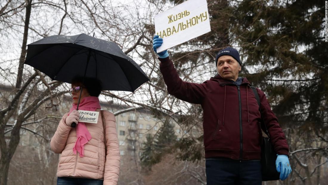 ノボシビルスクでナバリヌイ氏支持のボードを掲げる人々/Kirill Kukhmar/TASS/Getty Images