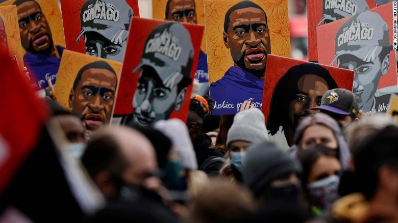 ジョージ・フロイドさんら、警官の暴力で命を落としたとされる人たちのイラストを掲げて集まる人々/Carlos Barria/Reuters