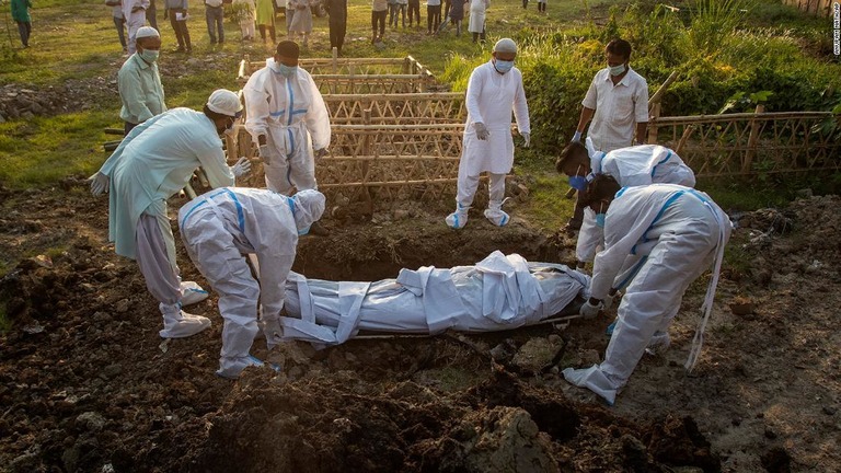 インド北東部ゴウハティで新型コロナ患者の遺体を埋葬する市の職員ら＝２５日/Anupam Nath/AP