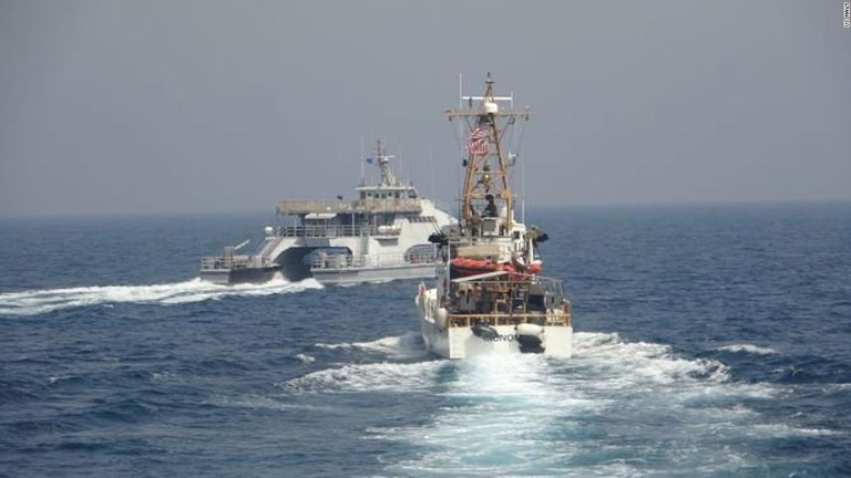 米沿岸警備隊の船（右）の船首を横切るイランの艦艇＝４月２日、ペルシャ湾南部の国際海域/US Navy