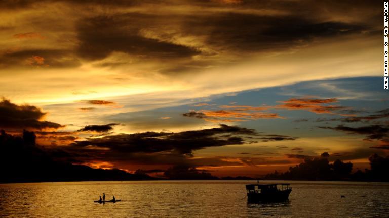 フローレス島の夕暮れ。伝統的な舟をこぐ漁師が見える/SONNY TUMBELAKA/AFP/AFP via Getty Images