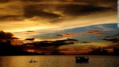 フローレス島の夕暮れ。伝統的な舟をこぐ漁師が見える