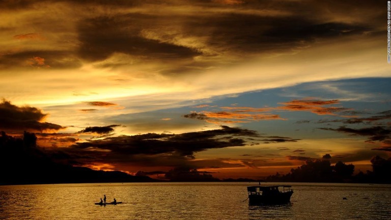 フローレス島の夕暮れ。伝統的な舟をこぐ漁師が見える/SONNY TUMBELAKA/AFP/AFP via Getty Images