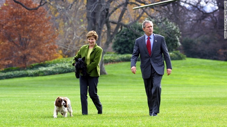 芝生を歩くブッシュ大統領夫妻とバーニー＝２００１年１２月/MANNY CENETA/AFP/Getty Images