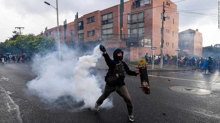 コロンビアの大統領官邸の外で催涙ガスを投げ返すデモ参加者＝１日、南米コロンビアの首都ボゴタ/JUAN BARRETO/AFP via Getty Images