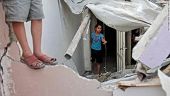 寝室の被害を調べるパレスチナ人の子ども＝１１日