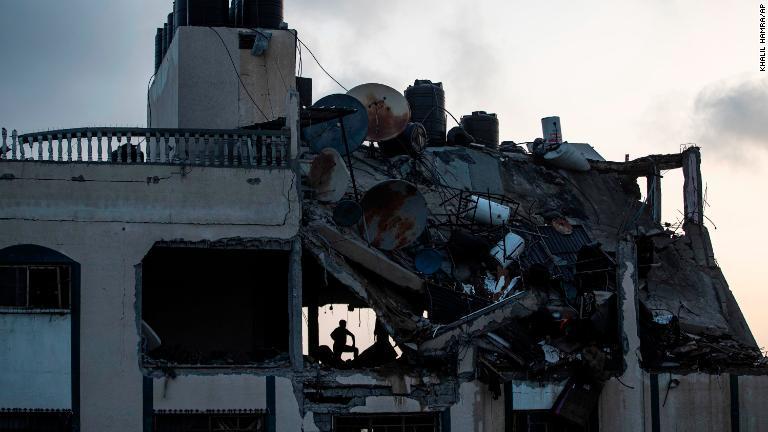 破損した建物で生存者を探す人＝１１日/Khalil Hamra/AP
