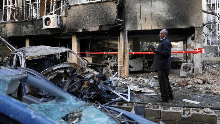 ロケット弾による被害を調べる男性＝１３日/Gil Cohen-Magen/AFP/Getty Images