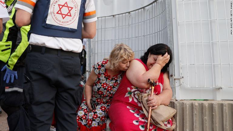 イスラエルの救急隊と住民＝１１日、イスラエル・アシュケロン/Jack Guez/AFP/Getty Images