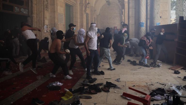 イスラム教の聖地「アルアクサ・モスク」でイスラエル警察と対峙するパレスチナの人々＝１０日/Mahmoud Illean/AP