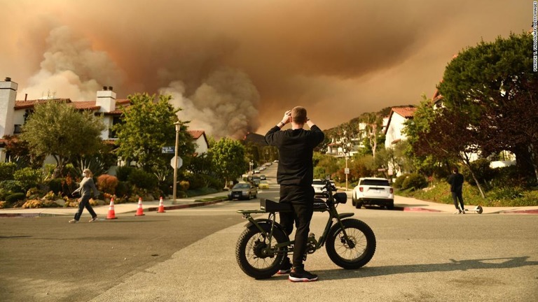 トパンガ州立公園で発生した山火事の煙を撮影する男性＝１５日/Patrick T. Fallon/AFP/Getty Images