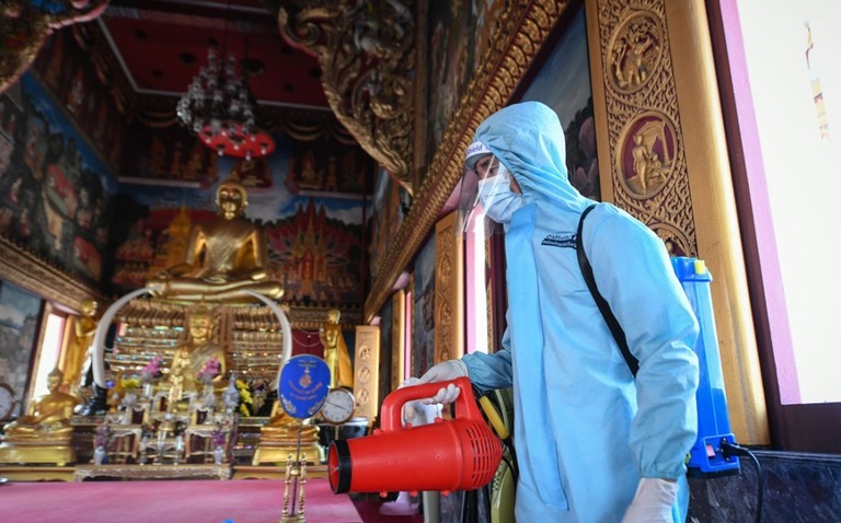 バンコクの寺院で防護具を身に着け消毒を行う救急作業員/Amphol Thongmueangluang/SOPA Images/LightRocket/Getty Images