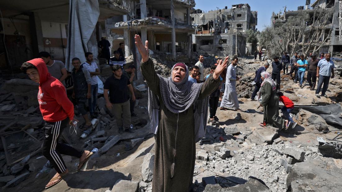 ガザ地区でイスラエル軍による空爆の被害を確認するパレスチナ人の人々/Mahmud Hams/AFP/Getty Images