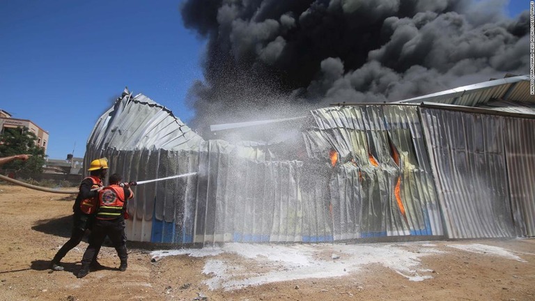 イスラエルからの空爆で被害に遭った倉庫の消火を試みる消防士ら＝１８日、パレスチナ自治区ガザ南部のラファ/Khaled Omar/Xinhua News Agency/Getty Images