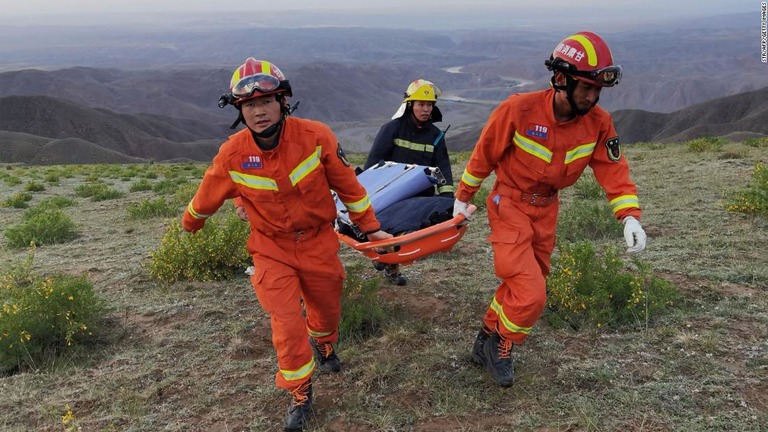 大会参加者を探す救急隊員。天候の急変により、参加したランナー２１人が死亡した/STR/AFP/Getty Images