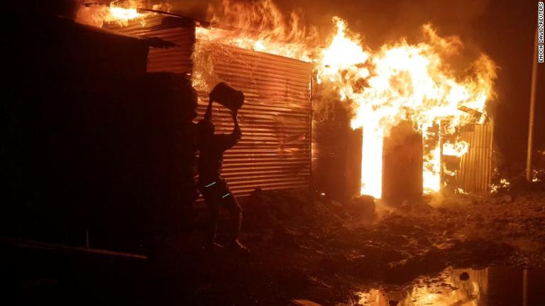 ゴマで消火を試みる人＝２２日/Enoch David/Reuters