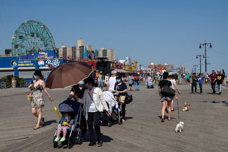 コニーアイランドを散歩する人々＝１９日、米ニューヨーク市/Angela Weiss/AFP/Getty Images