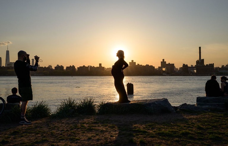 ニューヨーク・ブルックリンで夕日を背景に写真に収まる妊婦/Ed Jones/AFP/Getty Images