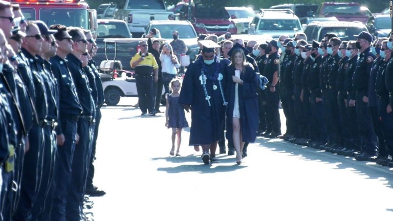消防士らが整列する中、卒業式の会場に向かうカーロンさんとその家族/OnScene.TV